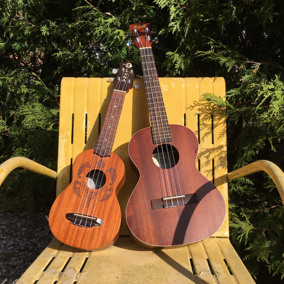 two ukuleles on a chair outside